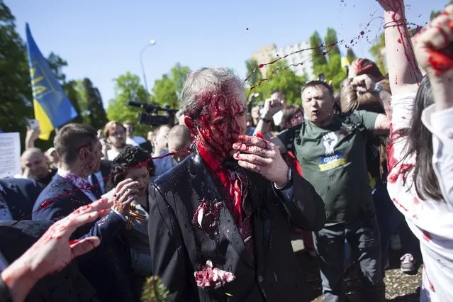 Russian Ambassador to Poland, Ambassador Sergey Andreev is covered with red paint in Warsaw, Poland, Monday, May 9, 2022. Protesters have thrown red paint on the Russian ambassador as he arrived at a cemetery in Warsaw to pay respects to Red Army soldiers who died during World War II. Ambassador Sergey Andreev arrived at the Soviet soldiers cemetery on Monday to lay flowers where a group of activists opposed to Russia’s war in Ukraine were waiting for him. (Photo by Maciek Luczniewski/AP Photo)