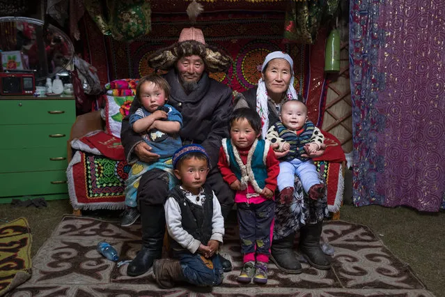 Sailau poses for a photo with his wife and grandchildren in Altai Mountains, Mongolia, September 2016. (Photo by Joel Santos/Barcroft Images)