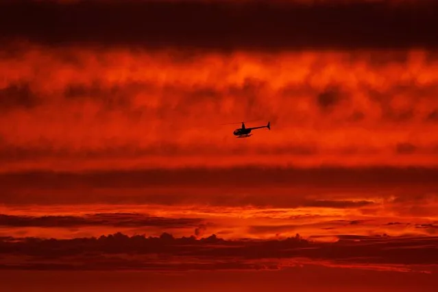 A helicopter travels south along the coast after sunset over the ocean as hurricane Hilary approaches Del Mar, California, U.S., August 19, 2023. (Photo by Mike Blake/Reuters)