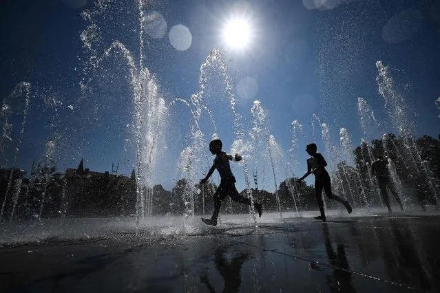 Children cool off as they run through a public fountain in Colmar, eastern France, on August 21, 2023, as France experiences a late summer heatwave. In the “hottest” episode of summer 2023 in France Météo-France has warned of an “intense and lasting” heat wave with 50 out of 96 departments in mainland France placed on orange vigilance saying “we could reach temperature levels never before seen in France”. The highest temperature ever recorded in France is 46 degrees in Verargues, in Herault, on June 28, 2019. (Photo by Sebastien Bozon/AFP Photo)