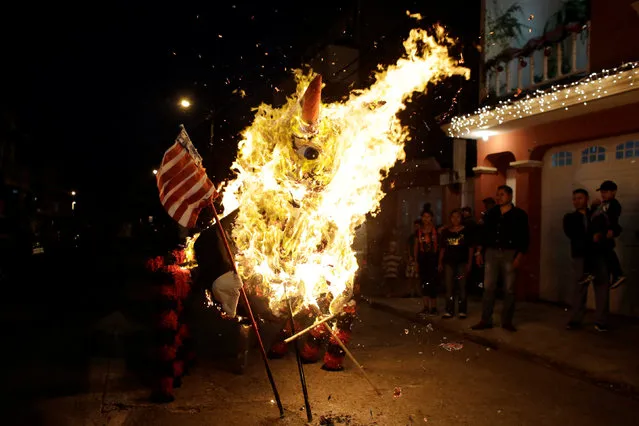 People look at a pinata representing U.S. President-elect Donald Trump as a devil burning during the traditional Burning of the Devil festival, ahead of Christmas in Guatemala City, Guatemala December 7, 2016. (Photo by Luis Echeverria/Reuters)