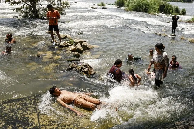 People cool off in the Nile river during a heat wave in al-Qanater al-Khayreya, on the outskirts of Cairo on July 19, 2023. (Photo by Khaled Desouki/AFP Photo)