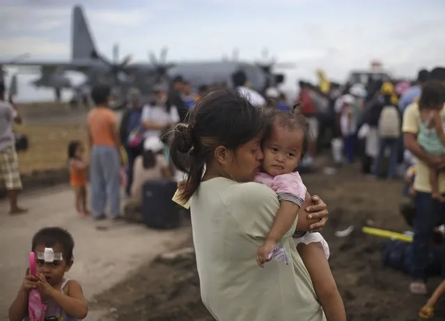 A woman survivor of Typhoon Haiyan weeps as she holds her daughter while waiting for her turn to get on a U.S. Air Force plane to leave for the capital city of Manila, at the airport in Tacloban, central Philippines, Wednesday, November 13, 2013. (Photo by Dita Alangkara/AP Photo)