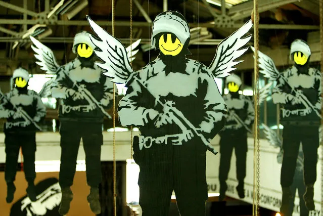 Cartoon images of policemen with wings and smiley faces are seen during a Banksy exhibition in London in 2003. (Photo by Reuters/Stringer)