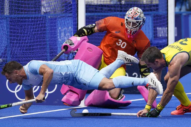 Argentina's Lucas Martin Vila (12) battles with Australia's Jeremy Thomas Hayward (32) on a scoring attempt on goalkeeper Andrew Lewis Charter (30) during a men's field hockey match against Australia at the 2020 Summer Olympics, Tuesday, July 27, 2021, in Tokyo, Japan. (Photo by John Minchillo/AP Photo)