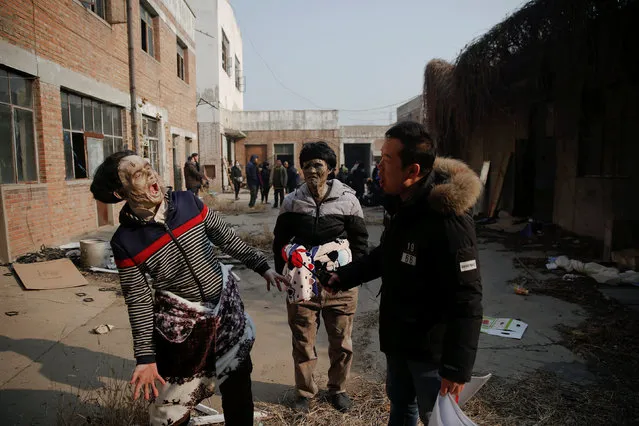 Actors rehearse their roles during the filming of the post-apocalyptic movie Zombie Era at an abandoned factory complex in Langfang, Hebei province, China December 16, 2016. (Photo by Damir Sagolj/Reuters)