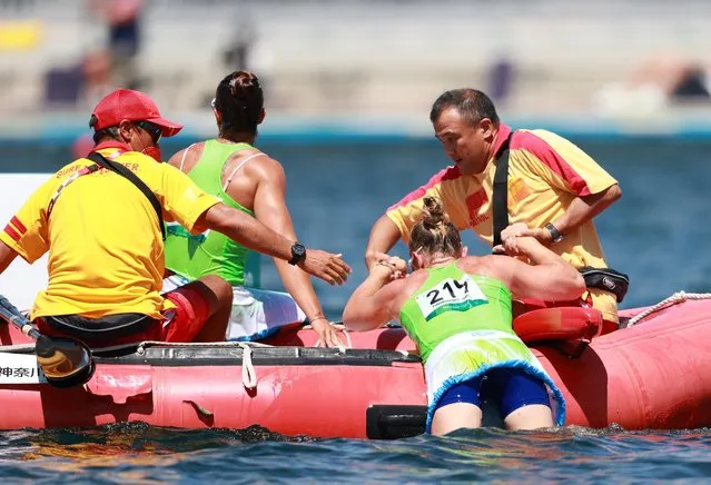 Slovenia's Spela Ponomarenko Janic and Slovenia's Anja Osterman are pulled out of the water after flipping their boat while competing in the women's kayak double 500m semi-final during the Tokyo 2020 Olympic Games at Sea Forest Waterway in Tokyo on August 3, 2021. (Photo by Yara Nardi/Reuters)