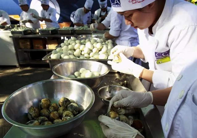Students from the Center for Culinary Art Manila crack open hundreds of Balut, a local delicacy of boiled duck embryo, during an attempt to make a Guinness World Record in the Pateros municipality, metro Manila April 10, 2015. (Photo by Romeo Ranoco/Reuters)
