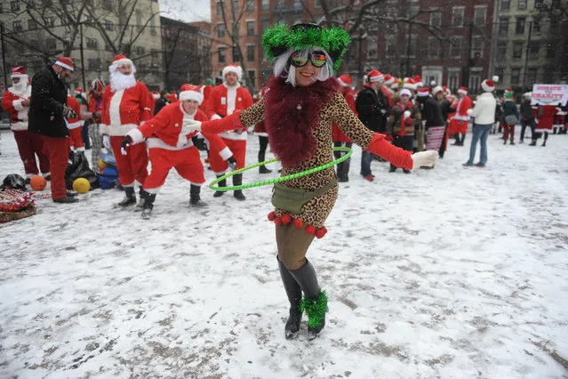 Christmas spirit at Tompkins Square Park in Manhattan as Suzi Hoops joins Santa's of all kind gather on this snowy day, December 12th, 2013. (Photo by John Roca)