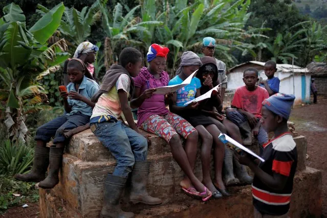 Kids gather and read school books in Boucan Ferdinand, Haiti, October 4, 2018. (Photo by Andres Martinez Casares/Reuters)