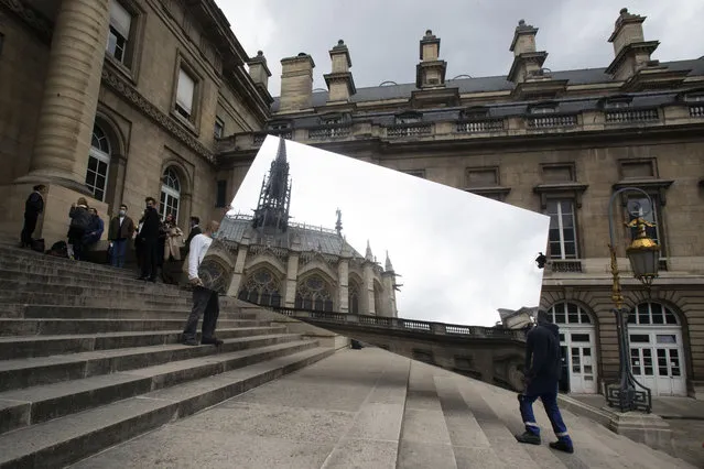 The Sainte Chapelle is reflected in a mirror carrying by workers at the Paris court, in Paris, Wednesday, May 5, 2021. (Photo by Thibault Camus/AP Photo)
