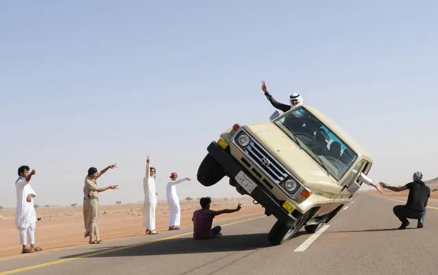 Saudi youths demonstrate a stunt known as “sidewall skiing” (driving on two wheels) in the northern city of Hail, in Saudi Arabia March 30, 2013. Performing stunts such as sidewall skiing and drifts is a popular hobby amongst Saudi youths. (Photo by Reuters)