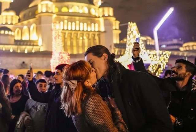A couple shares a kiss as they celebrate New Year's Eve in central Istanbul's Taksim Square, in Istanbul, Monday, January 1, 2024. (Photo by Emrah Gurel/AP Photo)