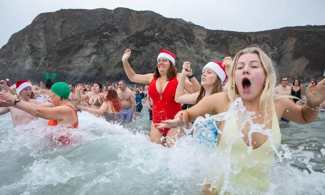 Swimmers taking part in the Christmas Day dip brave the waves in St Agnes, Cornwall, UK on December 25, 2023. (Photo by Jonny Weeks/The Guardian)