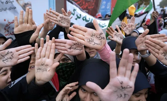 Iranian school girls show their hands with pro-government slogans and an anti-Israeli slogan which reads in Farsi: “Death to Israel”, during a rally in front of the former U.S. Embassy in Tehran, Iran, marking 44th anniversary of the seizure of the embassy by militant Iranian students, Saturday, November 4, 2023. (Photo by Vahid Salemi/AP Photo)