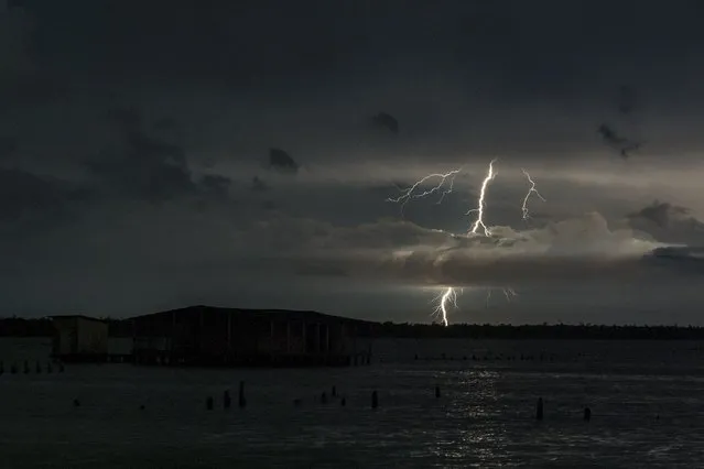 A lightning strikes over lake Maracaibo near the stilt houses of Chamitas in Catatumbo, Venezuela, on September 11, 2021. The “Catatumbo Lightning”, a series of unique storms in the world, is considered a “lighthouse” that, for centuries, has helped people when they sail in the dark. (Photo by Federico Parra/AFP Photo)