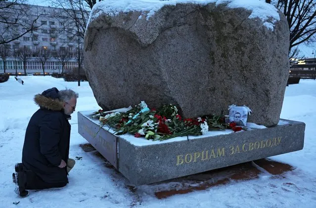 A man kneels at the monument to the victims of political repression in Saint Petersburg, Russia on February 16, 2024. (Photo by Reuters/Stringer)