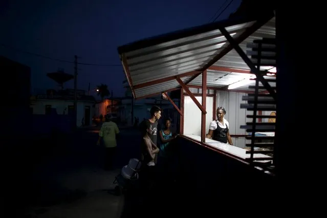 Neilae Bignotle, 23, talks to customers in a small snack shop in Regla, Cuba, March 17, 2016. (Photo by Alexandre Meneghini/Reuters)