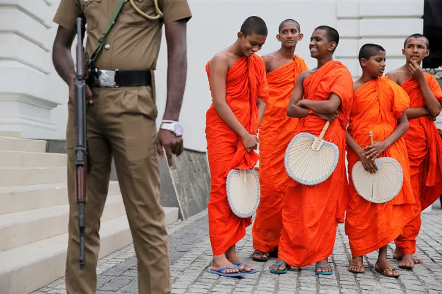 Monks are seen next to a security personnel after a Buddhist ceremony as a tribute to victims, a week after a string of suicide bomb attacks across the island on Easter Sunday, outside Kingsbury Hotel in Colombo, Sri Lanka on April 28, 2019. (Photo by Thomas Peter/Reuters)