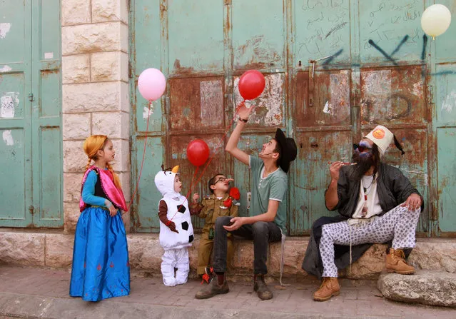 Dressed up Israeli settlers take part in a parade during the festivities of the Jewish holiday of Purim on March 24, 2016 in the West Bank town of Hebron. The carnival-like Purim holiday is celebrated with parades and costume parties to commemorate the deliverance of the Jewish people from a plot to exterminate them in the ancient Persian empire 2,500 years ago, as recorded in the Biblical Book of Esther. (Photo by Gil Cohen-Magen/AFP Photo)