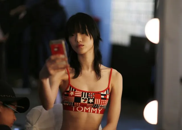 A model prepares in front of a cell phone before going out to the runway at the 2017 Tommy Hilfiger Runway Show in Venice, California, U.S., February 8, 2017. (Photo by Mario Anzuoni/Reuters)