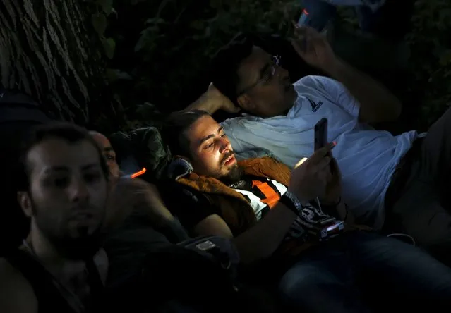 A Syrian immigrant calls friends on his mobile after crossing the borderinto Macedonia, along with another 45 Syrian immigrants,  near the Greek village of Idomeni in Kilkis prefecture May 14, 2015. (Photo by Yannis Behrakis/Reuters)