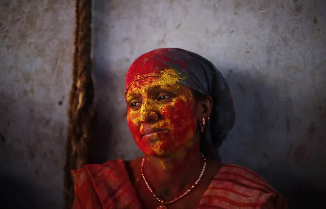 A Hindu woman is seen covered with coloured powder at a temple during “Lathmar Holi” at Nandgaon village, in the northern Indian state of Uttar Pradesh, March 10, 2014. (Photo by Adnan Abidi/Reuters)