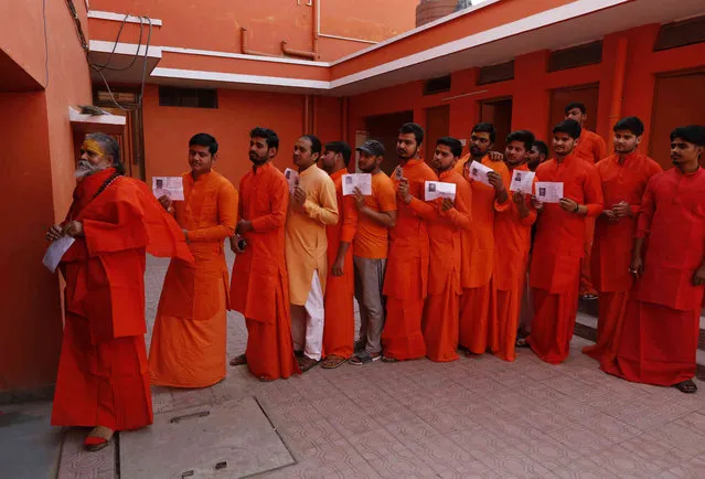 Hindu holy men, stand in a queue to cast their votes at a polling station in Prayagraj, Uttar Pradesh state, India , Sunday, May 12, 2019. Indians are voting in the next-to-last round of 6-week-long national elections, marked by a highly acrimonious campaign with Prime Minister Narendra Modi flaying the opposition Congress party rival Rahul Gandh's family for the country's ills. (Photo by Rajesh Kumar Singh/AP Photo)