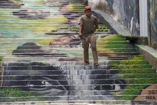 A man descends a stair mural depicting the slain Honduran environmental and Indigenous rights activist Berta Caceres, in Cantarranas, Honduras, Saturday, November 27, 2021, one day ahead of the general elections. Political related violence prior to Sunday’s elections has reached unprecedented levels with close to 30 murders considered to have been motivated by or involving politicians. Francisco Gaitan, the mayor of Cantarranas who was seeking his fifth re-election was murdered on Nov. 13. (Photo by Moises Castillo/AP Photo)