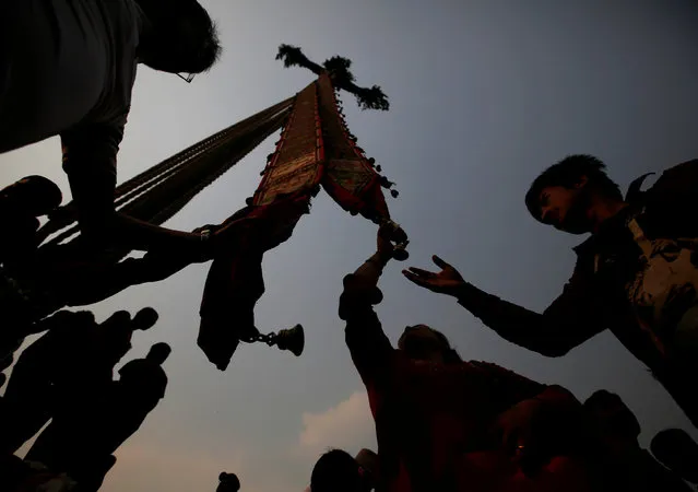 Devotees are silhouetted as they gather under the “lingo”, a long wooden pole representing a phallus, before pulling it down during the Bisket festival at Bhaktapur, Nepal, April 13, 2016. (Photo by Navesh Chitrakar/Reuters)