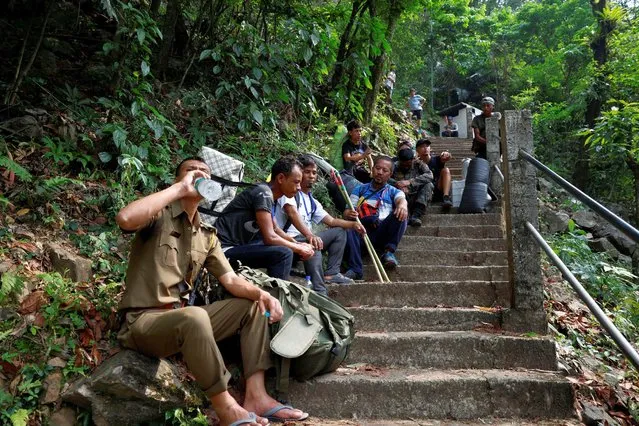 Polling officers and porters rest on their way to reach a remote polling station, ahead of the first phase of the election, in Shillong, in the northeastern state of Meghalaya, India, on April 17, 2024. (Photo by Adnan Abidi/Reuters)