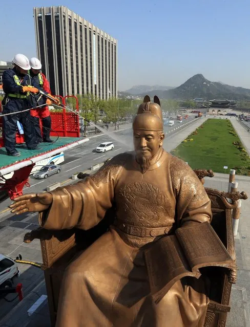 Workers spray water on the bronze statue of King Sejong at Gwanghwamun Square in downtown Seoul, South Korea, 18 April 2016, to remove dirt in a springtime clean-up. Sejong, the 4th king of the Joseon Dynasty (1392-1910), created the Korean alphabet, hangeul, in 1446. (Photo by EPA/Yonhap)