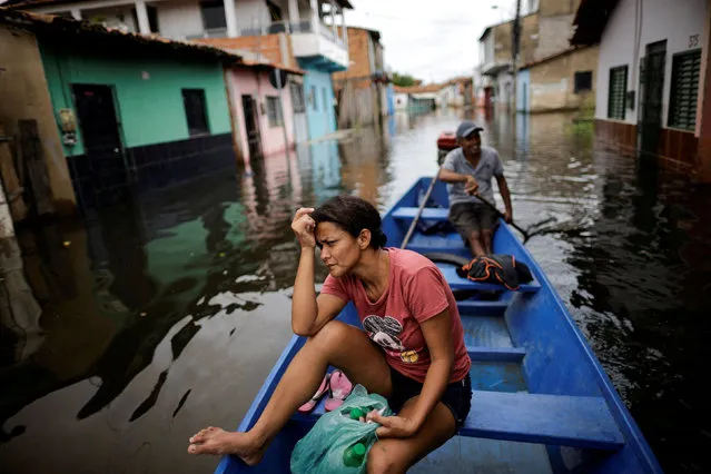 A woman looks on from a canoe after leaving her flooded house during floods caused by heavy rain in Maraba, Para state, Brazil on January 9, 2022. (Photo by Ueslei Marcelino/Reuters)