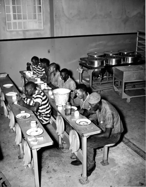 Inmates take a break to eat at the Georgia State Prison's new location near Reidsville, Tattnall County, on September 6, 1937. (Photo by AP Photo)