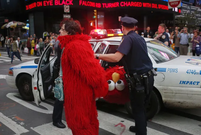 A man, dressed as the Muppet character Elmo, is arrested in New York's Times Square September 18, 2012. The arrest took place after a loud verbal exchange between the man and tourists, witnesses said. The police at the scene did not give a reason for the arrest. (Photo by Adrees Latif/Reuters)