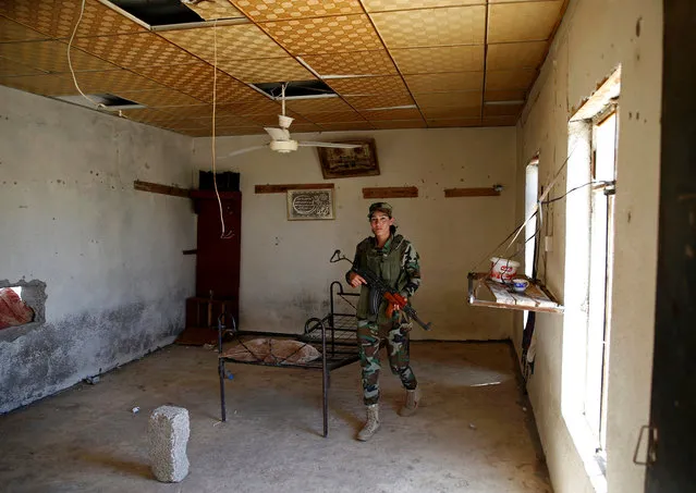 Yazidi female fighter Asema Dahir, 21, holds her weapon during a deployment at a site near the frontline of the fight against Islamic State militants in Nawaran near Mosul, Iraq, April 20, 2016. When Islamic State swept into the northern Iraqi town of Sinjar in 2014, a few young Yazidi women took up arms against the militants attacking women and girls from their community. (Photo by Ahmed Jadallah/Reuters)