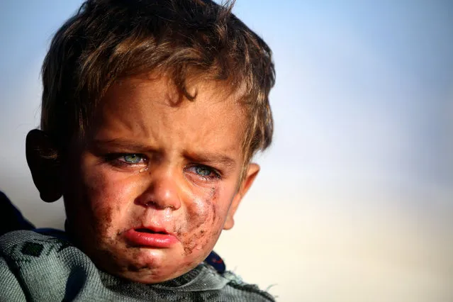 A Syrian boy cries as he is being held at a temporary refugee camp in the village of Ain Issa, housing people who fled Islamic State group's Syrian stronghold Raqa, some 50 kilometres (30 miles) north of the group's de facto capital on March 25, 2017. (Photo by Delil Souleiman/AFP Photo)