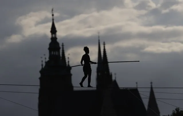 French tightrope walker Tatiana-Mosio Bongoga balances over the Vltava river during her performance to open an international new circus festival in Prague, Czech Republic, Wednesday, August 14, 2019. The Prague Castle is in the background. (Photo by Petr David Josek/AP Photo)