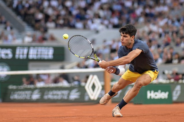 Spain's Carlos Alcaraz Garfia plays a backhand return to Greece's Stefanos Tsitsipas during their men's singles quarter final match on Court Philippe-Chatrier on day ten of the French Open tennis tournament at the Roland Garros Complex in Paris on June 4, 2024. (Photo by Bertrand Guay/AFP Photo)