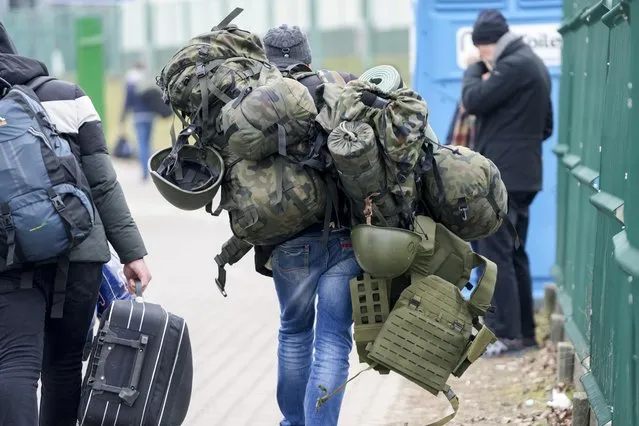 A man carries combat gear as he leaves Poland to fight in Ukraine, at the border crossing in Medyka, Poland, Wednesday, March 2, 2022. (Photo by Markus Schreiber/AP Photo)