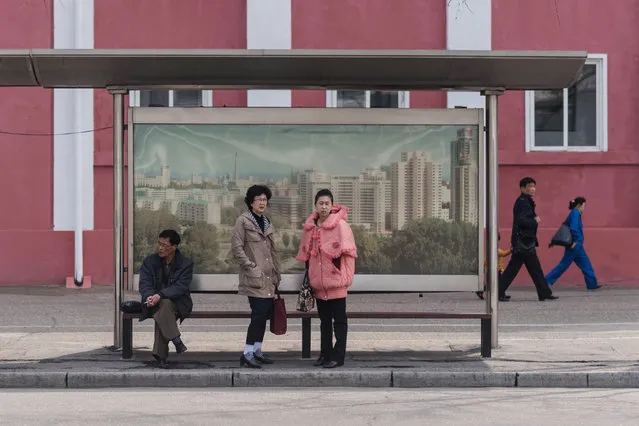 In a photo taken on April 7, 2017 commuters wait at a bus stop in Pyongyang. (Photo by Ed Jones/AFP Photo)