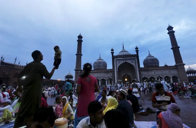 A Muslim man balances his nephew on his palm before his iftar (breaking of fast) meal during the holy month of Ramadan at the Jama Masjid (Grand Mosque) in the old quarters of Delhi, India, July 10, 2015. (Photo by Adnan Abidi/Reuters)