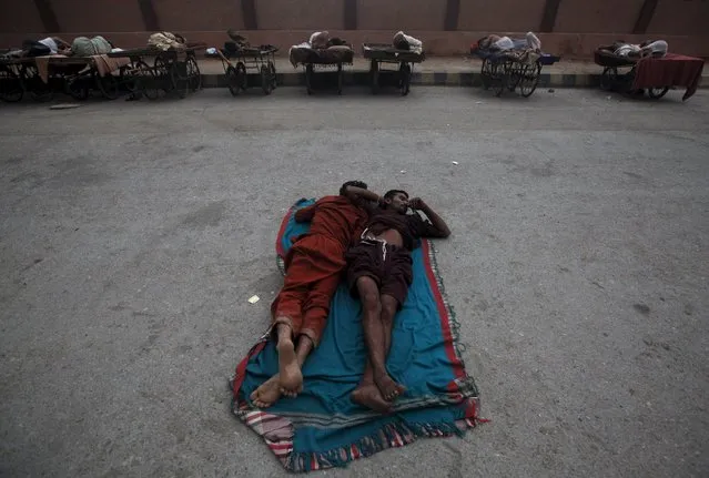 Men sleep on a street in the early morning to escape the heat during a major power breakdown in Karachi, Pakistan, July 8, 2015. A K-Electric spokesman said that almost half of Karachi city fell into darkness after the main power line from Bin Qasim power plant tripped on Tuesday evening, local media reported. (Photo by Athar Hussain/Reuters)