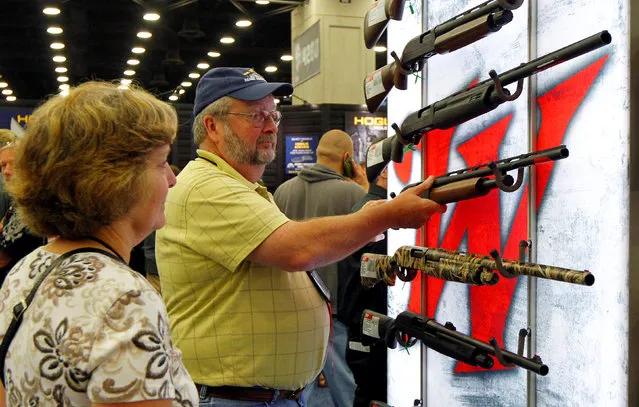 Gun enthusiasts look over Winchester guns at the National Rifle Association's annual meetings & exhibits show in Louisville, Kentucky, May 21, 2016. (Photo by John Sommers II/Reuters)