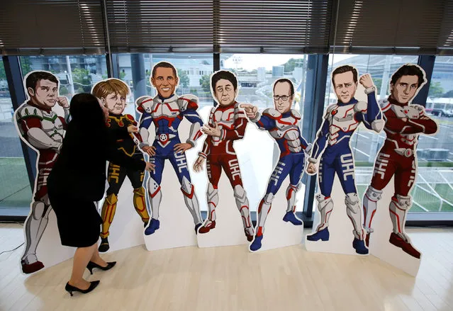 A staff member of the G7 Network of Health-related NGOs in Japan tries to adjust positions of cutout panels presenting the G7 countries' leaders as superheroes, aimed to express civil society's high expectation of them, at the G7 NGO center located next to the International Media Centre in Ise, Mie Prefecture, Japan May 25, 2016. (Photo by Issei Kato/Reuters)