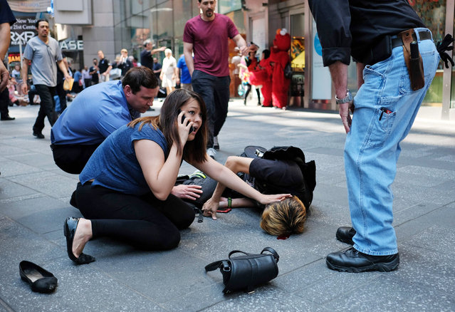 People attend to an injured man after a car plunged into him in Times Square in New York on May 18, 2017. (Photo by Jewel Samad/AFP Photo)