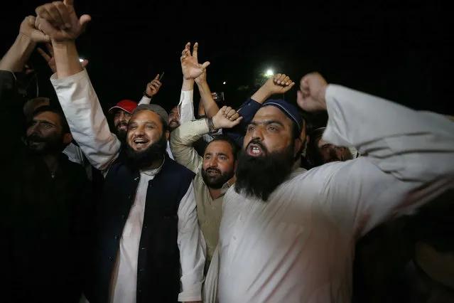 Supporters of an opposition party chant slogans as they celebrate the success of a no-confidence vote against Prime Minister Imran Khan outside the National Assembly, in Islamabad, Pakistan, Sunday, April 10, 2022. (Photo by Anjum Naveed/AP Photo)