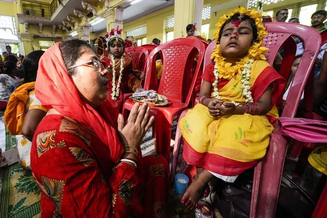 A young girls who is yet to attain puberty is dressed up as living goddesses and worshipped as “kumari” or virgin during Bengali Hindu festival Basanti Durga Puja in Kolkata, India, Sunday, April 10, 2022. (Photo by Bikas Das/AP Photo)