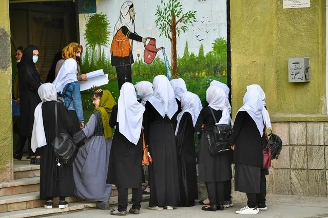 Girls arrive at their school in Kabul on March 23, 2022. The reopening of secondary schools for girls across Afghanistan on March 23 prompted joy and apprehension among the tens of thousands of students deprived of an education since the Taliban's return to power. (Photo by Ahmad Sahel Arman/AFP Photo)