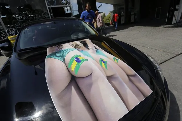 A Lebanese supporter of Brazil's national football team displays his car decorated for the FIFA World Cup 2014 on June 10, 2014 in Beirut. Brazil kicks off the World Cup today hoping to unite the football-mad country after a chaotic seven-year build-up plagued by violent protests. (Photo by Joseph Eid/AFP Photo)